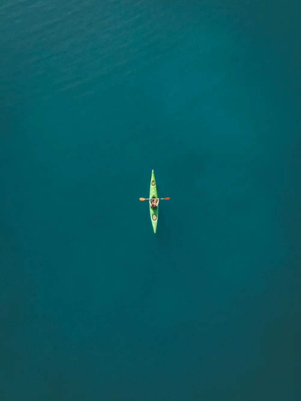 Kayak visto desde el aire sobre agua turquesa