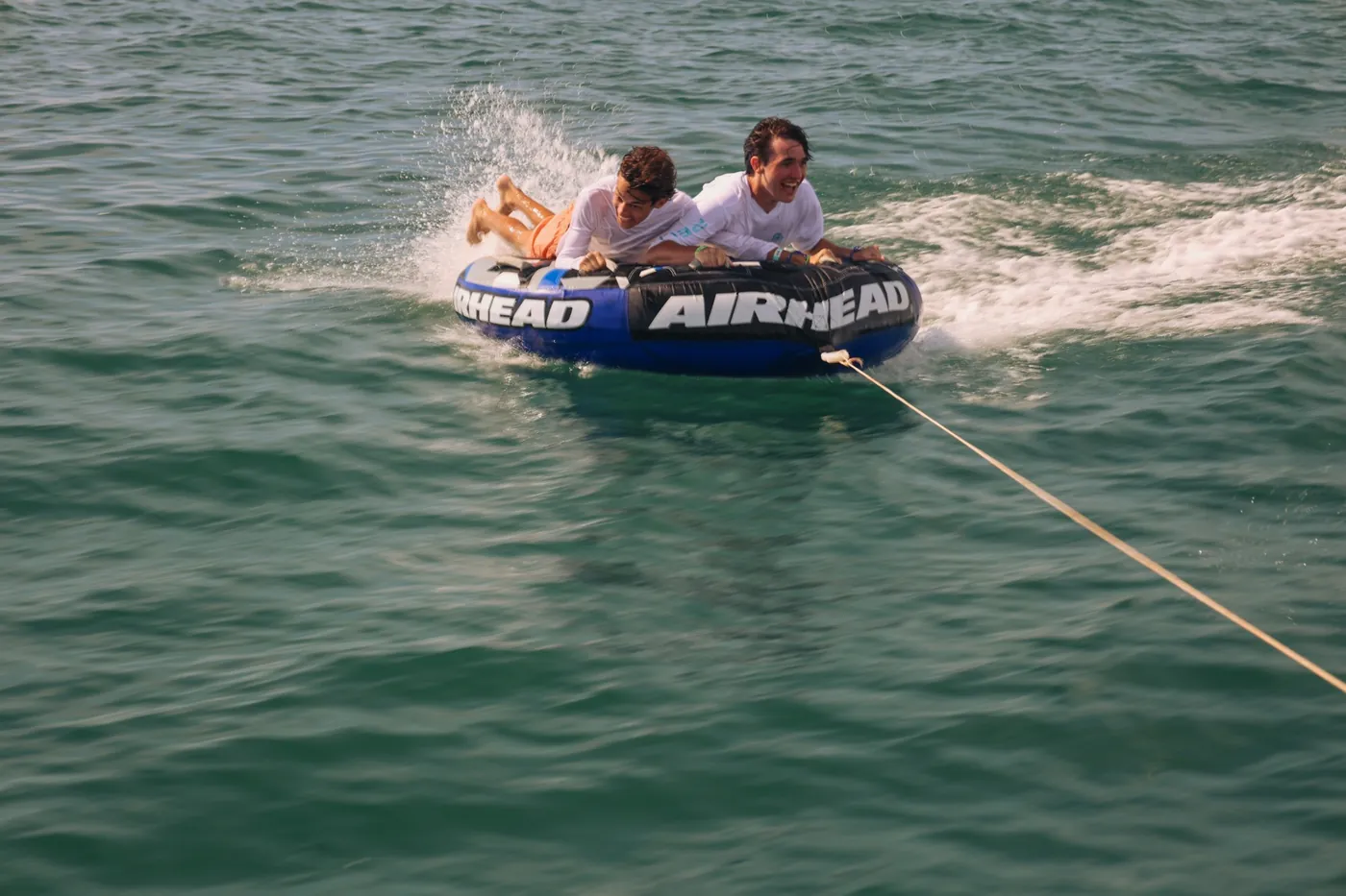 Dos personas haciendo tubing en el mar