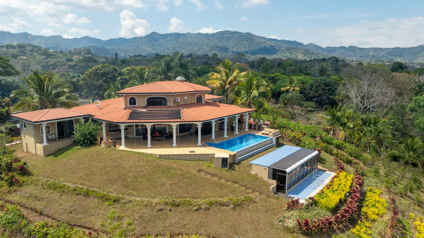 Vista aérea de una villa con piscina entre montañas
